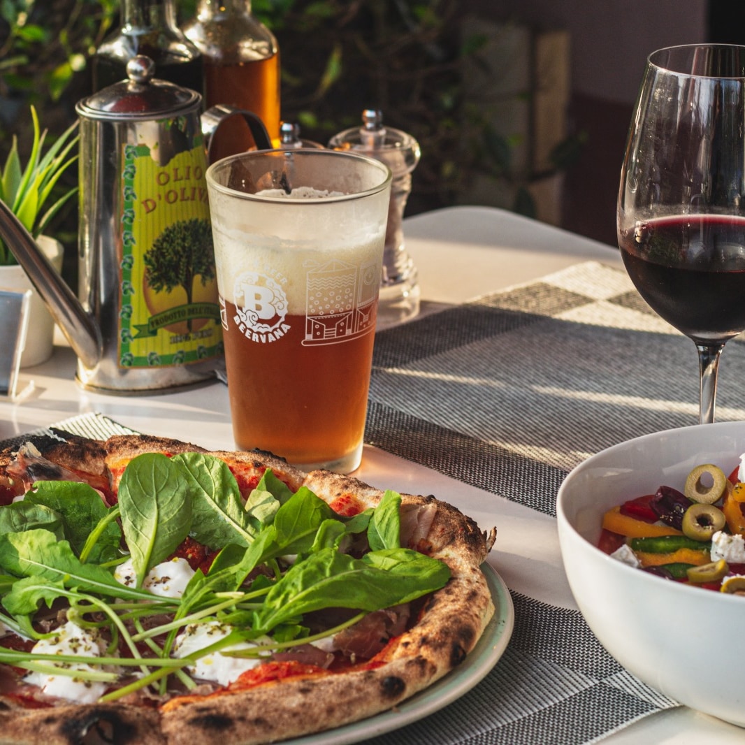 Pizza with arugula and burrata, beer and wine