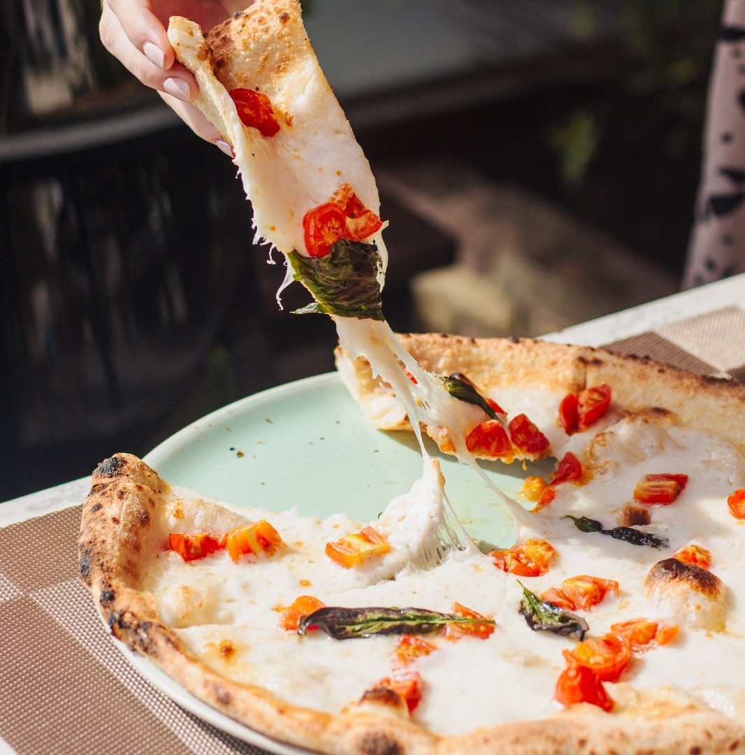 White pizza with cherry tomatoes and stretchy mozzarella